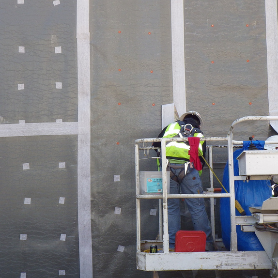 Worker installing Carlisle MiraPly V waterproofing membrane
